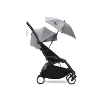 Stokke® YOYO® Parasol in Stone color attached to a black stroller, featuring a compact design and adjustable sunshade.