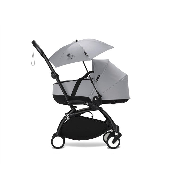 Stokke® YOYO® Parasol in Stone color attached to a stroller featuring a small seat and protective canopy.