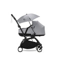 Stokke® YOYO® Parasol in Stone color attached to a stroller featuring a small seat and protective canopy.