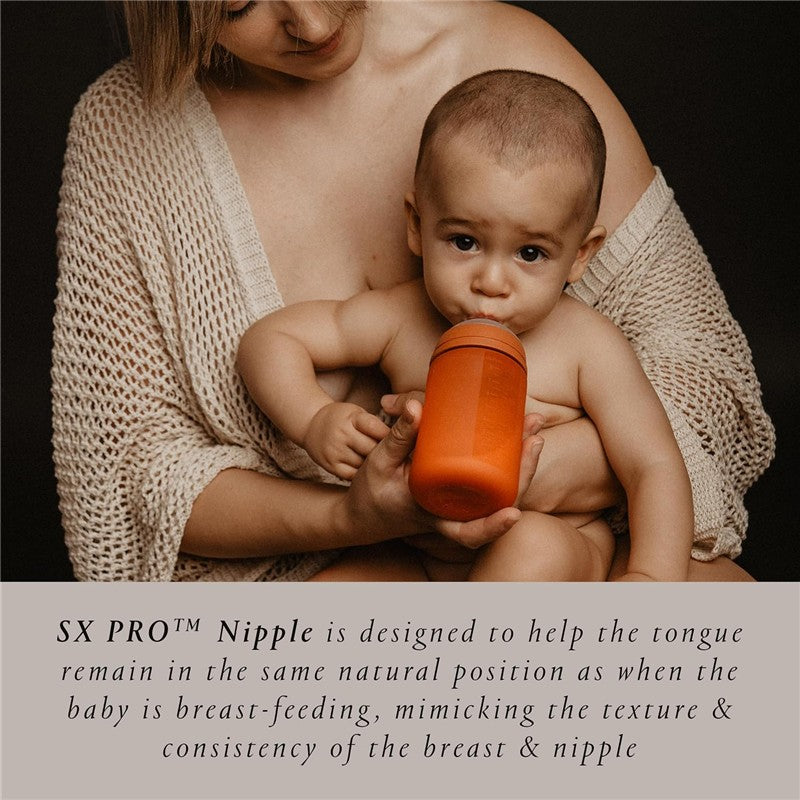 Silicone bottle in Irish Cream color held by a caregiver with a baby, highlighting the SX PRO™ Nipple design for breastfeeding support.