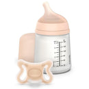 Suavinex Zero Zero Newborn Starter Set featuring a small anti-colic baby bottle and matching pacifier in a pale color.
