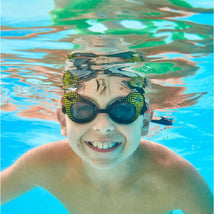 Swimways DC Batman Swim Goggles on a smiling child underwater, showcasing black frames with yellow bat symbol details.