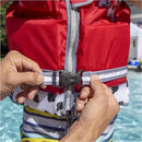 A child wearing a red Swimways Marshall Swim Trainer Life Jacket with a zipper and gray straps, being fastened at a pool.
