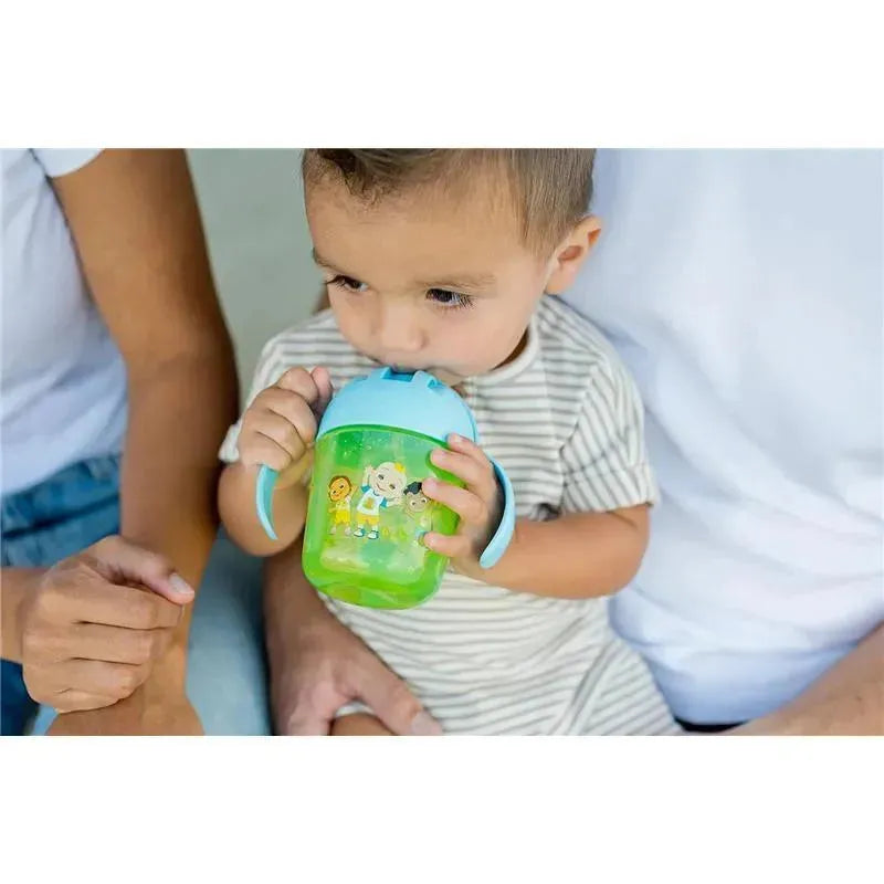 Toddler holding a green Cocomelon kids weighted trainer cup with handles, drinking from it while seated.