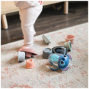 Disney Stitch 7oz weighted straw trainer cup is on the floor among various small nesting cups, with a child standing nearby.