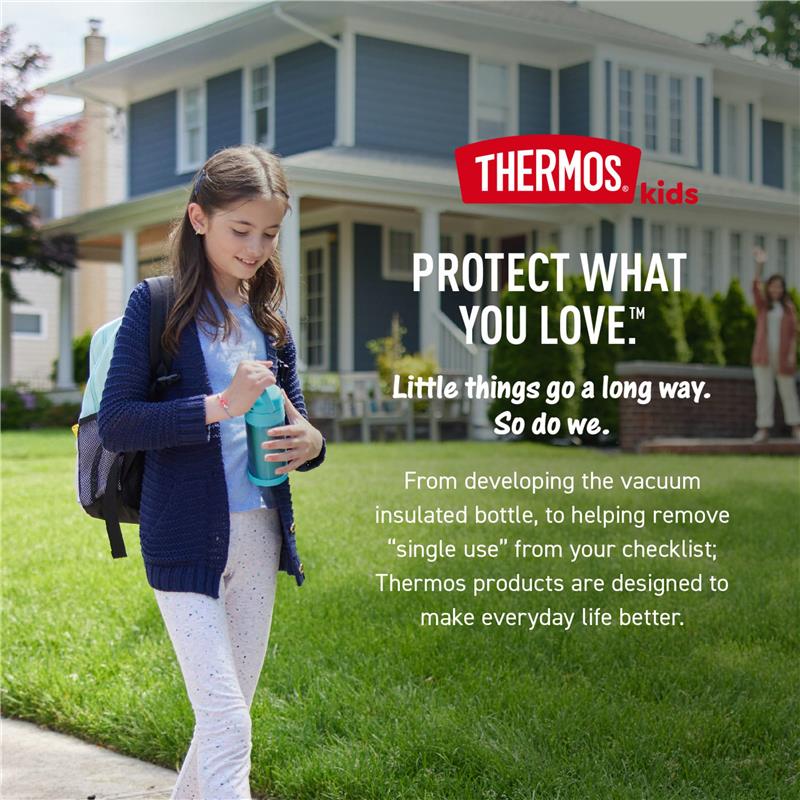 A girl with long hair holds a blue Thermos Funtainer food jar while standing on a lawn in front of a house.