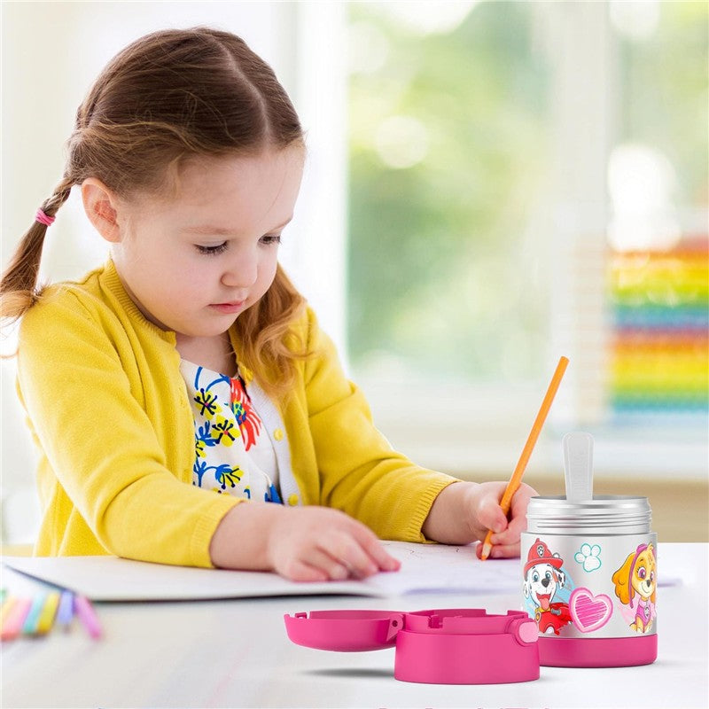 Thermos FUNtainer 10 oz food jar in pink with Paw Patrol characters, next to a girl writing with a pencil.