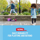 Girls playing in a park near lunchboxes and a pink Thermos water bottle, with a message about durability for kids.