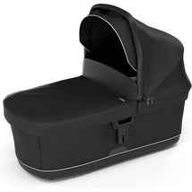 Black Thule Bassinet with a sunshade, featuring a sleek design and zippers for easy access and functionality.
