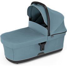 Bassinet Mid in blue, featuring a covered design with a sturdy handle and zippered compartments for convenience.