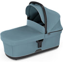Bassinet Mid in blue, featuring a covered design with a sturdy handle and zippered compartments for convenience.
