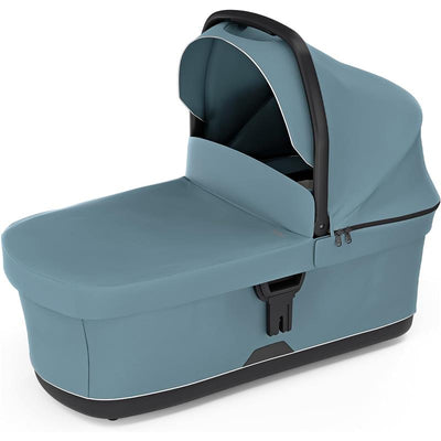 Bassinet Mid in blue, featuring a covered design with a sturdy handle and zippered compartments for convenience.