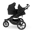 Thule Bassinet in soft beige, attached to a black stroller frame with large wheels and a sleek design.