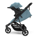 Thule Spring 2 single child stroller in mid blue, featuring a folded canopy and a spacious storage basket.