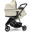 Thule Spring 2 single child stroller in soft beige, featuring a canopy, adjustable seat, and a storage basket.