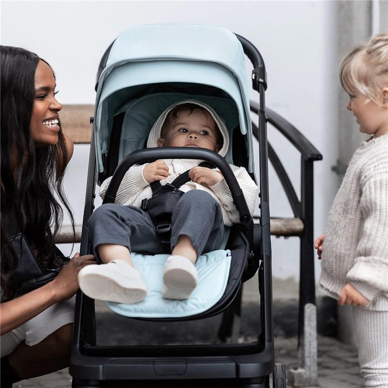 Thule Summer Seat Liner Alaska in a stroller with a baby, accompanied by a smiling woman and a girl.
