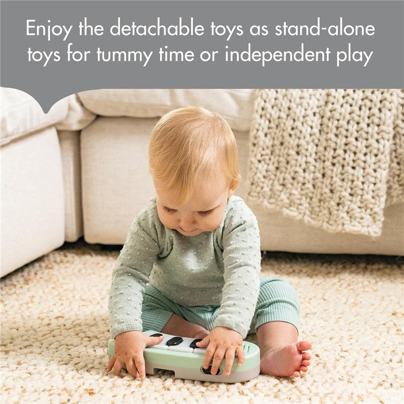 A baby plays with a mint green activity toy on a cream rug, enjoying detachable toys for tummy time or independent play.