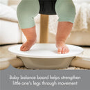 Tiny Love 5-in-1 Here I Grow Stationary Activity Center features a baby on a balance board, promoting leg strength through movement.