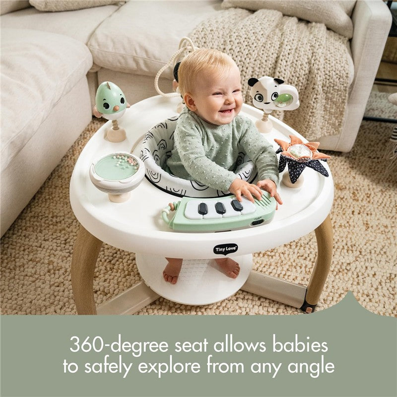 Tiny Love 5-in-1 Here I Grow Activity Center in black and white, featuring a smiling baby engaging with toys and a musical keyboard.
