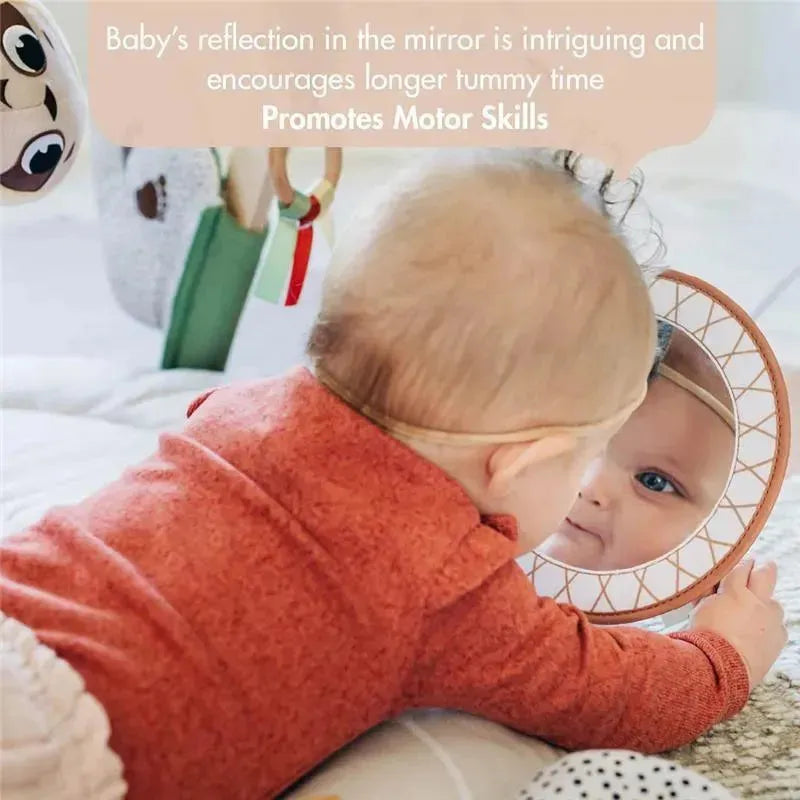 Baby on a play mat looks into a round mirror, promoting motor skills and tummy time; colorful toys are nearby.
