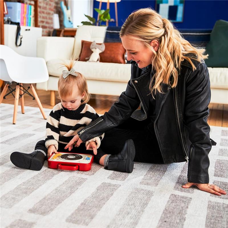 Mother and toddler interact with the Tiny Love Tiny Rockers Dj Station Toy, featuring colorful buttons and a turntable design.