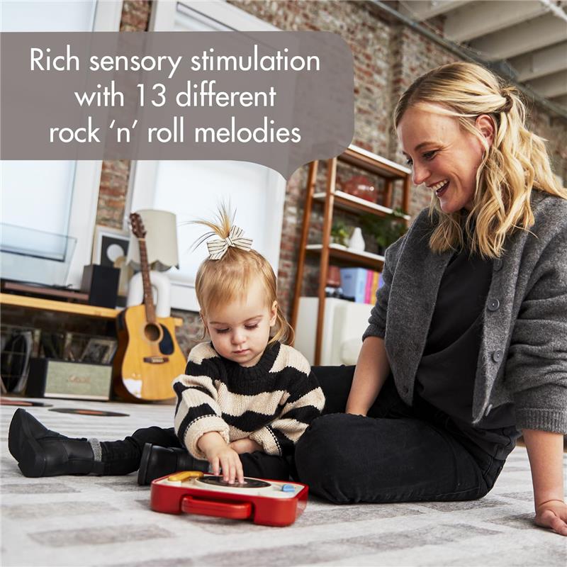 Toddler playing with Tiny Love - Tiny Rockers Dj Station Toy, enjoying music stimulation with an adult nearby.