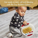 A toddler in a heart-patterned shirt plays with the Tiny Love Tiny Rockers Guitar, a colorful musical toy featuring buttons and a handle.