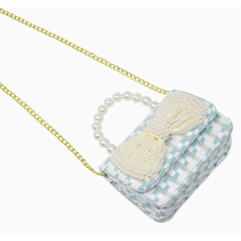 Blue tweed purse with a pearl handle and bow detail, designed for stylish accessory use.