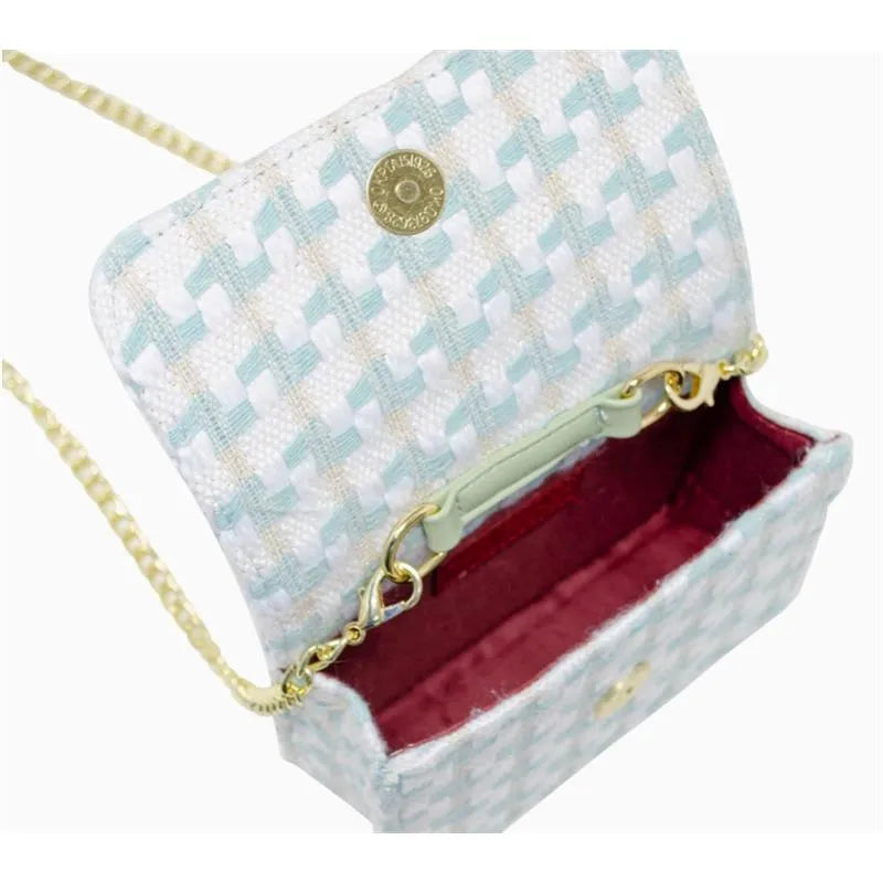 Tweed pearl handle bow purse in blue, featuring a woven pattern, chain strap, and a red interior.
