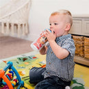 Child sitting on a colorful play mat, drinking from a Disney Mickey Mouse insulated sippy cup.