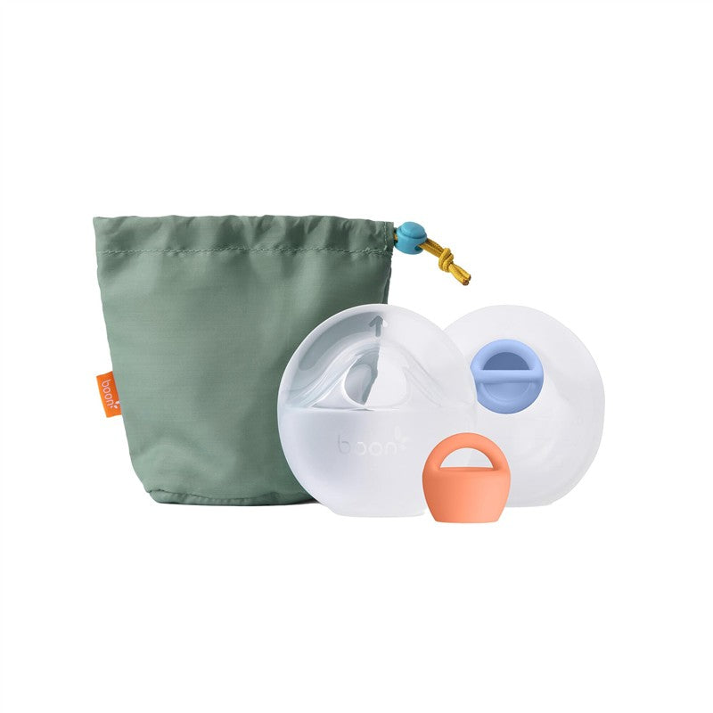 Boon TROVE silicone breast milk collection cups in a green storage pouch, featuring two clear cups and a light orange handle.
