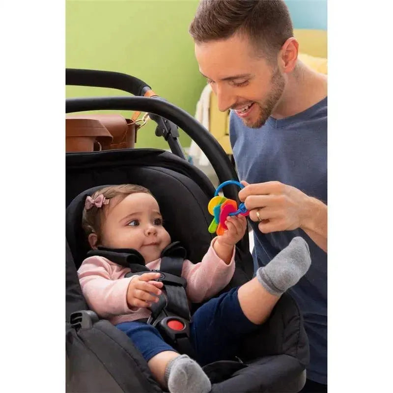 A parent engages a baby in a car seat, displaying colorful Tomy Lamaze My First Keys for play.