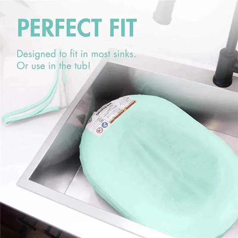 Puff inflatable bather in a sink, designed for infants, featuring a mint color and safety instructions on the label.