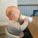 Child using a Tomy - The First Years Bluey insulated sippy cup while sitting at a table.