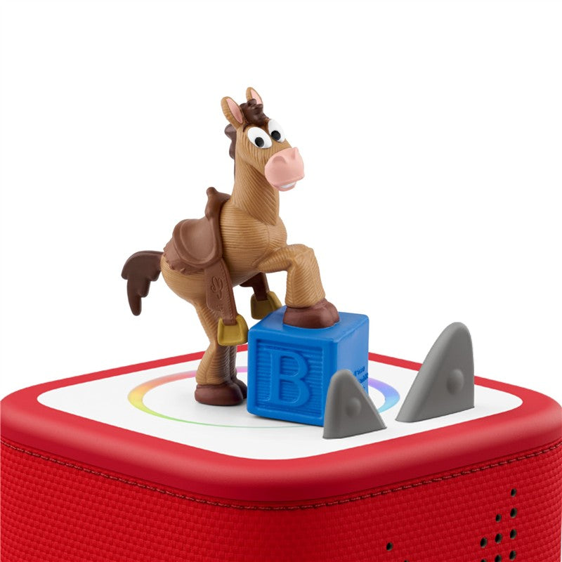 Tonies Bullseye figurine from Toy Story 5 stands on a blue block atop a red audio toy speaker.