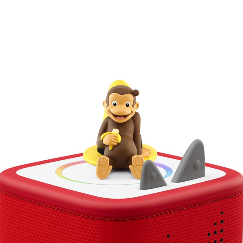 Curious George audio toy figurine sits on a red speaker, featuring buttons and a colorful interface.