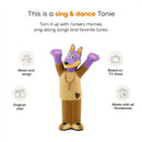 Doggyland Audio Toy Figurine with arms raised, featuring a purple dog character in a brown outfit, showcases music and songs from a TV show.