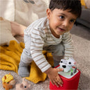 Soft and squeezable cow, pig, and horse figurines by Tonies, with a toddler playing and smiling in a cozy setting.