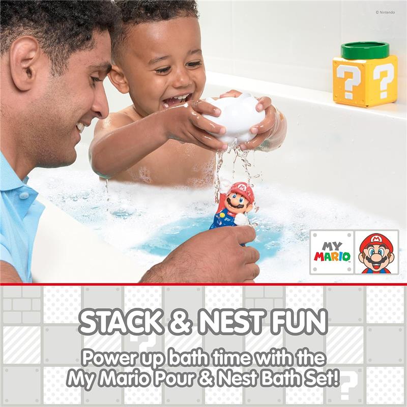 A smiling child holds a Mario figure in a bath, splashing water, with an adult nearby and colorful bath toys.