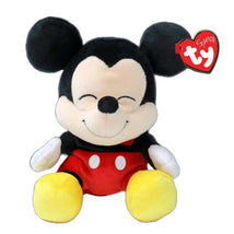 Floppy plush toy of Mickey Mouse with black ears, red shorts, and yellow shoes, smiling with a Ty tag attached.