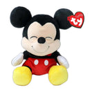 Floppy plush toy of Mickey Mouse with black ears, red shorts, and yellow shoes, smiling with a Ty tag attached.