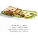 Reusable silicone storage bag in olive green, featuring a sandwich, apple slices, and almonds, designed for clean eating.