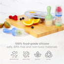 Ubbi Baby Food Feeder & Freezer Tray Set in Polaris Blue and Zest Green with fruits on a wooden cutting board.