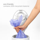 Eco-friendly Ubbi diaper pail bag in a person’s hand, made from 50% recycled material, being fitted into a pail.