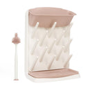 Vertical drying rack with multiple pegs for holding bottles and accessories, accompanied by a bottle brush, both in soft colors.
