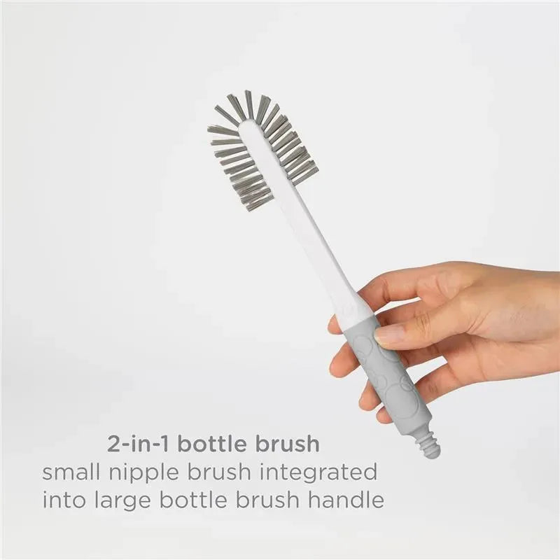 2-in-1 bottle brush featuring a small nipple brush integrated into a large handle, held by a hand against a light background.