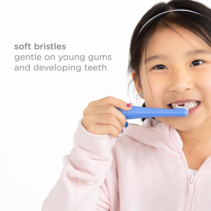 Toddler brushing teeth with a soft-bristled blue toothbrush, emphasizing gentle care for young gums and developing teeth.