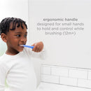 Toddler using a blue toothbrush with an ergonomic handle, designed for age 12 months and up, while brushing his teeth.
