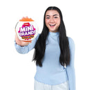 A young woman with long black hair holds a round packaging of Zuru Mini Brands Create, smiling, wearing a light blue top.