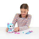 Girl in a striped long-sleeve shirt cares for a blue plush puppy from the Pets Alive series, with accessories nearby.
